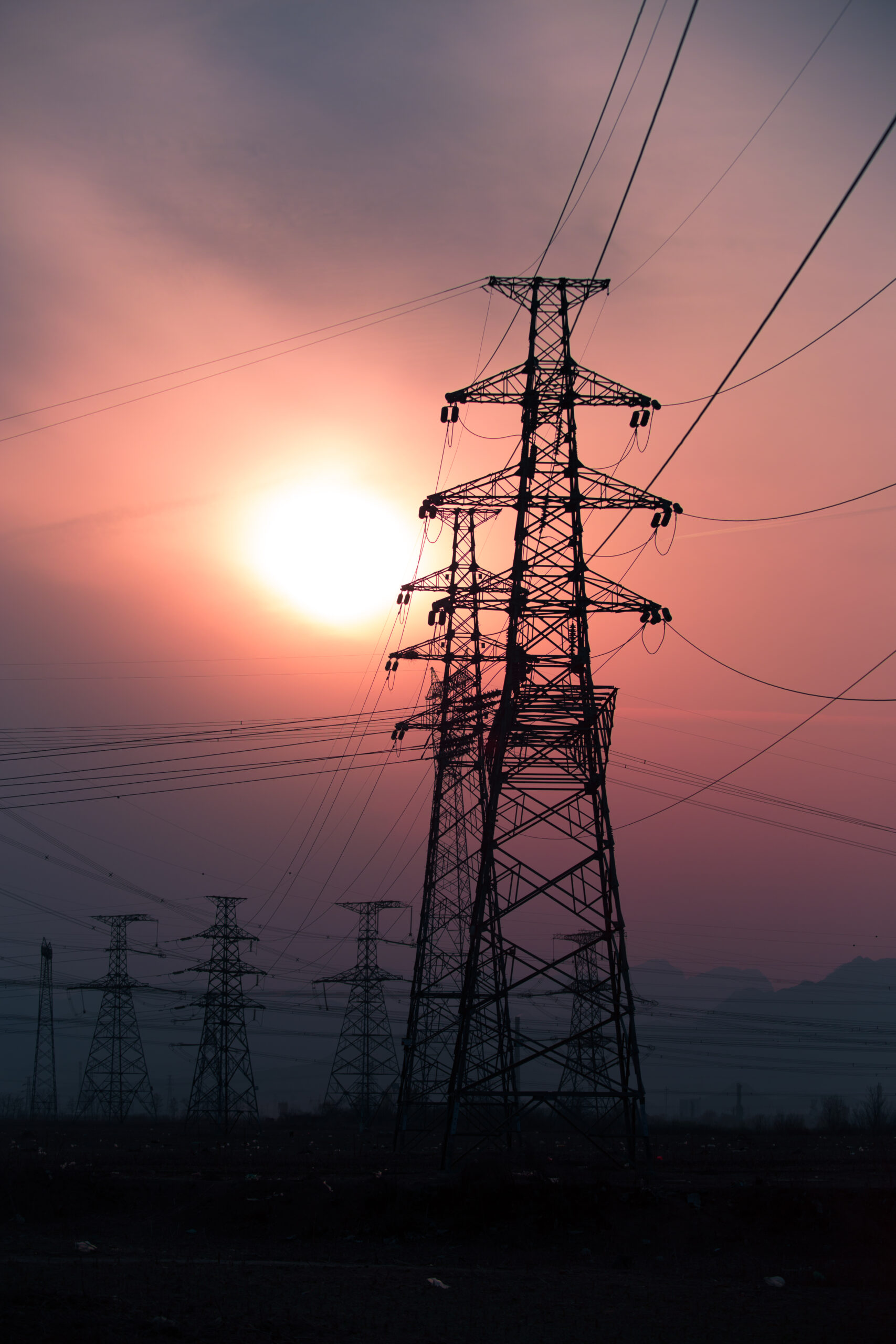 High voltage electricity pylon over sunset.
